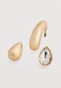 Σετ σκουλαρίκια σε χρυσή απόχρωση που περιλαμβάνει δύο λείες, στρογγυλές μπίλιες και ένα δάκρυ σε σχήμα με διακοσμητικό διαφανές πολύγωνο πετράδι.