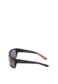 Gafas de sol negras con lentes oscuros, que cuentan con un detalle rojo en la patilla. Material ligero con un diseño elegante y envolvente.