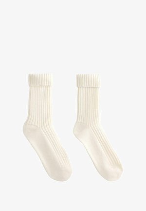 Chaussettes en coton de couleur crème, à rayures, avec un revers et une surface texturée, présentant des zones de renfort au niveau des orteils et du talon pour plus de durabilité.
