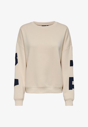 Bēša klasiska džemperis ar apaļu izgriezumu un gariem piedurknēm, melni lielgabalu burti uz abām piedurknēm, ribota aproce un apakša, ikdienišķs stils.