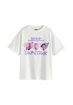 White T-shirt with purple text "KPOP Demon Hunters HUNTRX" and three illustrated female characters inside heart shapes.
