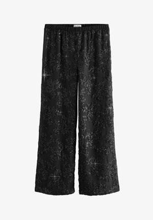 Pantalons larges noirs avec un motif texturé de paillettes brillantes, une taille élastique et une finition en tissu lisse.