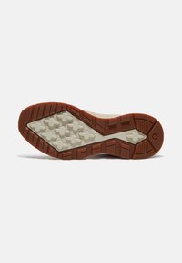 Gummisohle in braunen und creamfarbenen Tönen; mit hexagonalen Profilmustern und Rillen für Traktion. Robustes und strukturiertes Design.