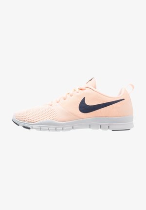 Chaussure de course Nike rose clair avec logo swoosh noir, tige en mesh, semelle blanche et design à lacets, vue de côté.