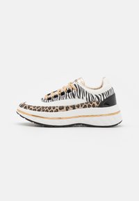 Sneaker bianca con stampa zebra e leopardata, dettagli dorati e suola in gomma nera. Presenta lacci beige e un design a piattaforma imbottita.