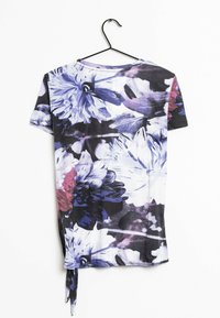 Tričko s květinovým vzorem v purpurových, modrých a černých odstínech. Krátké rukávy, kulatý výstřih a detail s bočním vázáním. Měkká, lehká tkanina.