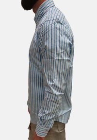 Camicia a righe con bottoni caratterizzata da righe verticali blu e bianche, maniche lunghe, colletto a punta e design aderente.