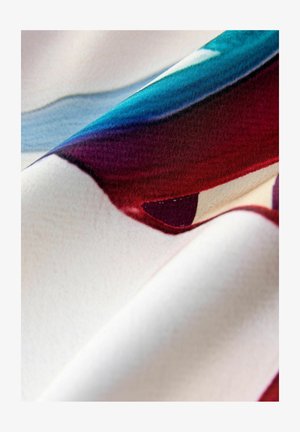 Tessuto con vivaci motivi astratti in tonalità di rosso, blu e crema, caratterizzato da una texture liscia e un morbido caduta.