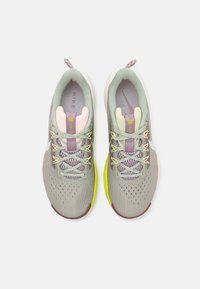 Jasnoszare buty sportowe z siateczkowym wzorem, warstwowymi pastelowymi akcentami, płaskimi sznurowadłami i jaskrawożółtą podeszwą.