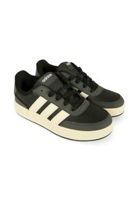 Czarno-szare buty sportowe z białym wzorem trzech pasków, skórą teksturowaną, sznurowanym zapięciem i gumową podeszwą. Wyjątkowe logo na języku.