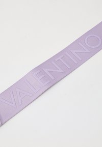 Valentino ljubičasti gumeni remen s utisnutim imenom branda u podebljanom, modernom fontu, s teksturiranom površinom za bolji grip.
