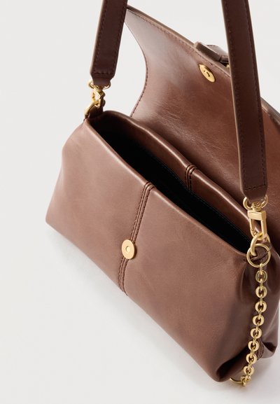 Καφέ δερμάτινη γυναικεία τσάντα με χρυσό μαγνητικό κούμπωμα, ανοιχτό πάνω κάλυμμα και χρυσή αλυσίδα στη λουρί της ώμου.