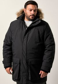 Svart parkajakett med pälsfodrad huva, med blixtlås och tryckknappsstängning, framfickor och en mjuk textur.