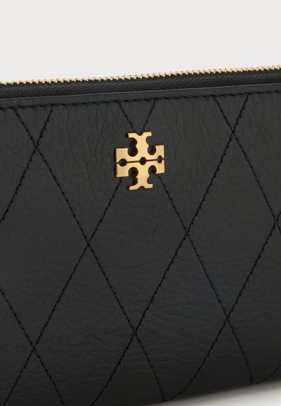 Μαύρο δερμάτινο πορτοφόλι με ραμμένο μοτίβο διαμαντιού και μικρό χρυσό μεταλλικό λογότυπο κοντά στην πάνω άκρη του φερμουάρ.
