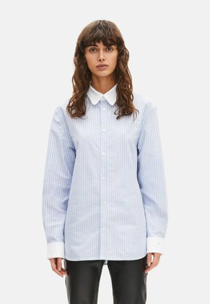 Lyseblå og hvide stribede skjorte med knapper, klassisk krave og lange ærmer. Har hvide manchetter og en afslappet pasform.