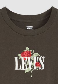 Camiseta de algodón verde oscuro con la inscripción "LEVI'S" en blanco, con bordado de una rosa roja y hojas verdes que realzan el diseño.