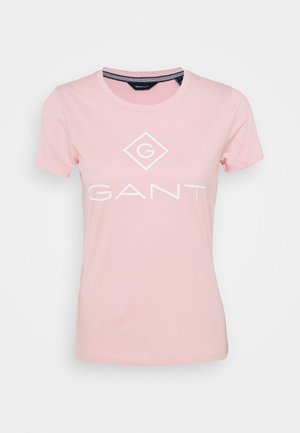 T-shirt en coton rose clair à manches courtes, col rond, avec le texte imprimé en blanc "GANT" ainsi qu'un logo en forme de diamant à l'avant.