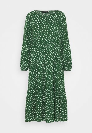 Abito floreale verde con maniche lunghe, scollatura rotonda, design a strati e motivi di fiori bianchi su un tessuto testurizzato.