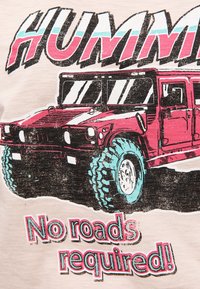 Grafische t-shirt met een rode Hummer met turquoise accenten en grote banden. De tekst eronder luidt: "Geen wegen nodig!" op een beige achtergrond.