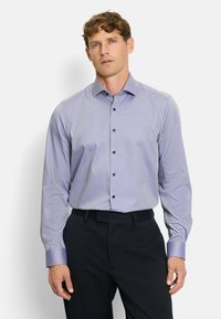 Light purple long-sleeve shirt with a dotted pattern, button placket with dark buttons, and contrasting collar details. Paired with dark trousers.