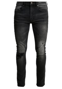 Mustat kapealahkeiset farkut, jotka on valmistettu denimi-kankaasta. Ne sisältävät kulutettuja yksityiskohtia, kuten polvissa olevia repeämiä, viiden taskun mallin ja klassisen napillisen suljennan.