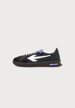 Sort-hvid lavtop sneakers med en stor hvid pil på siden, hvide snørebånd med lilla detalje og "OFF" tekst på sålen.