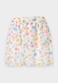 Jupe à volants blanche avec imprimé floral, présentant des fleurs pastel et des accents verts. Fabriquée en tissu léger, avec une taille froncée.