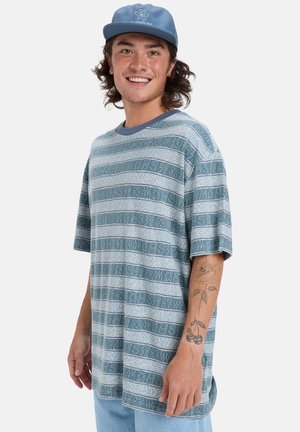 Blue patterned short-sleeve t-shirt with horizontal stripes, featuring a crew neck and a soft texture. Worn with a coordinating blue cap.