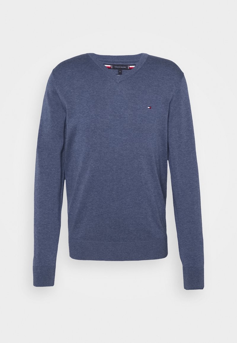 Pull bleu marine à manches longues avec col en V, petit logo rouge, blanc et bleu sur la poitrine gauche, poignets et bas côtelés.