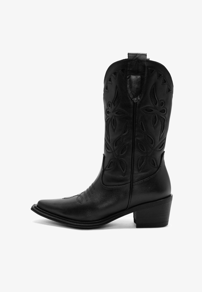 Bota vaquera de cuero negro con puntera afilada, costuras detalladas, patrones de corte en forma de flor y un tacón en capas.