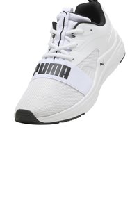 Sneaker atletica bianca con tomaia in rete e accenti neri. Presenta un audace logo "PUMA" sulla parte centrale del piede e una suola in gomma testurizzata.