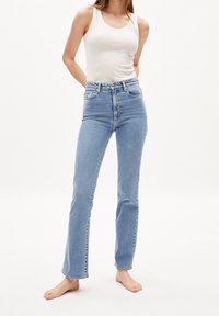 Vaaleansiniset korkeavyötäröiset farkut suoran lahkeiden muotoilulla, joissa on viisi taskua, vyölenkit ja hieman haalistunut pinta.