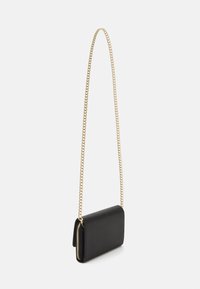 Sac en cuir noir à bandoulière avec une chaîne dorée, doté d'une fermeture éclair et d'une forme rectangulaire, texture lisse, design minimaliste.