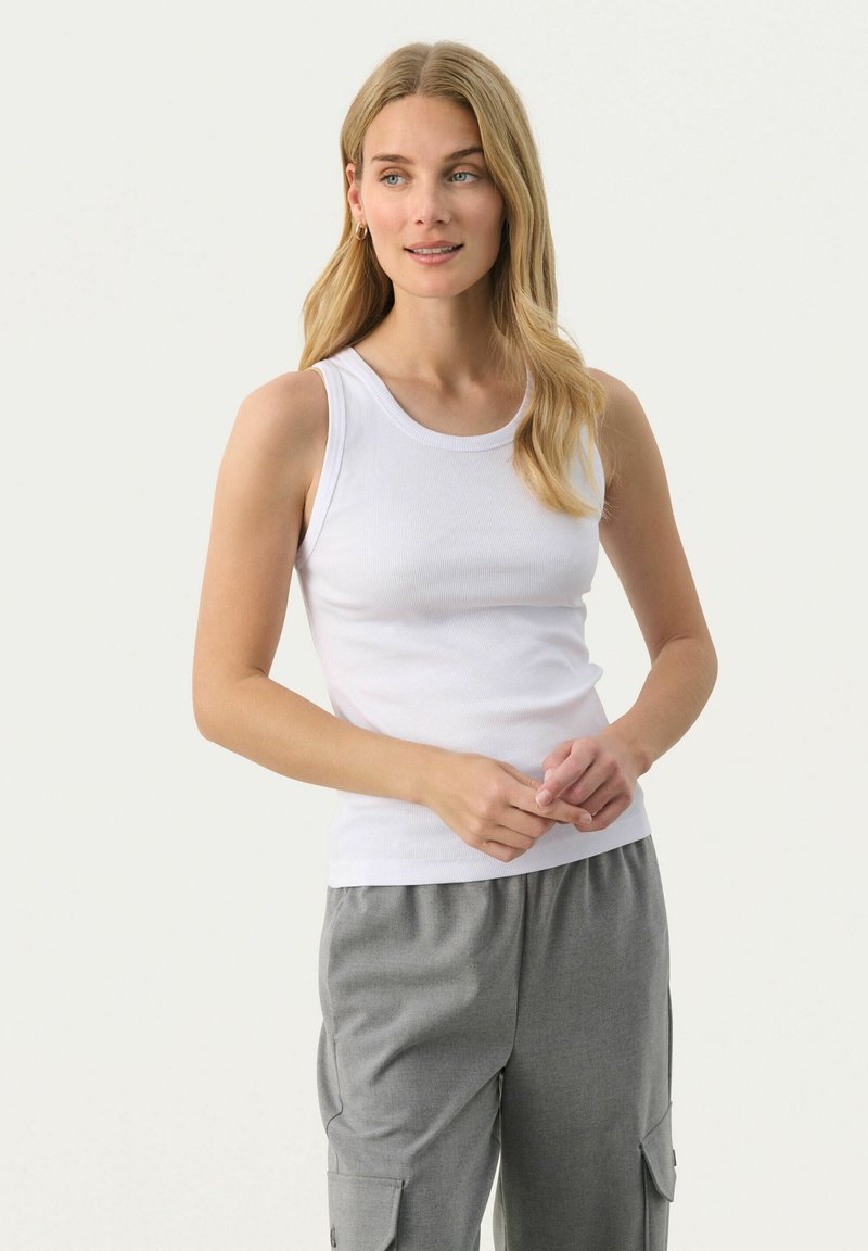 Valkoinen puuvillainen hihaton paita, jossa on pyöreä kaula-aukko ja ribbitekstuuri, yhdistettynä harmaisiin nyöripö trousers, joissa on sivutaskut.