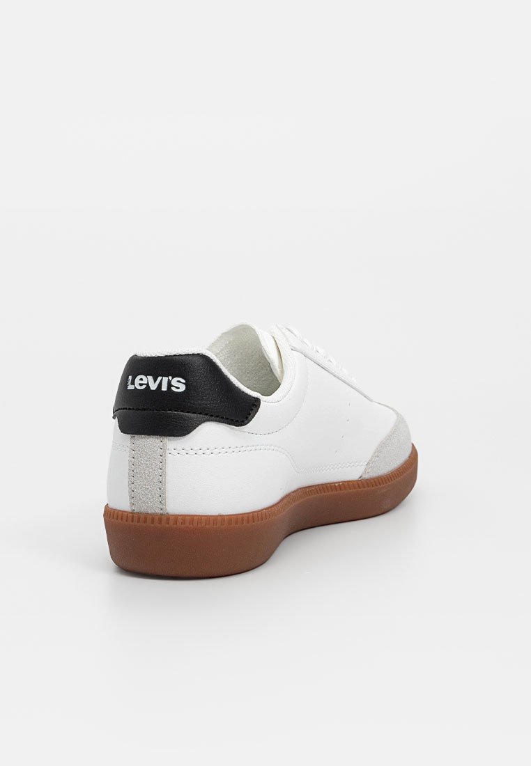 Zapatilla de cuero blanca con acento en el talón en negro y gris, suela de goma texturizada y diseño minimalista, que incluye detalles perforados a los lados.