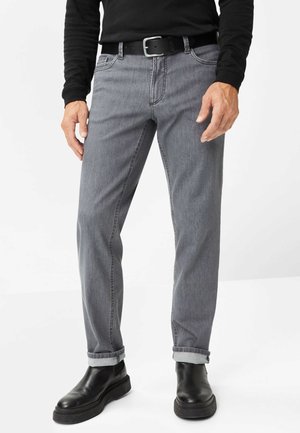 Jeans in denim grigio con taglio dritto, orli risvoltati, cuciture sottili, tasche frontali e abbinati a stivali in pelle nera.