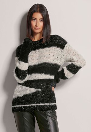 Schwarzer und weißer gestreifter Strickpullover mit lockerer Passform und langen Ärmeln, ausgestattet mit einem strukturierten Muster und kontrastierenden Garnakzenten.
