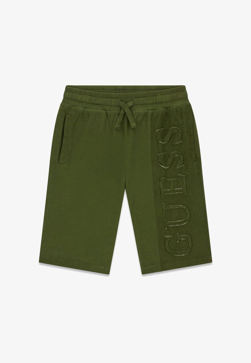 Shorts verts olive mi-cuisses avec taille élastique, cordon de serrage, poches latérales et logo "GUESS" en relief sur le panneau de la jambe droite.