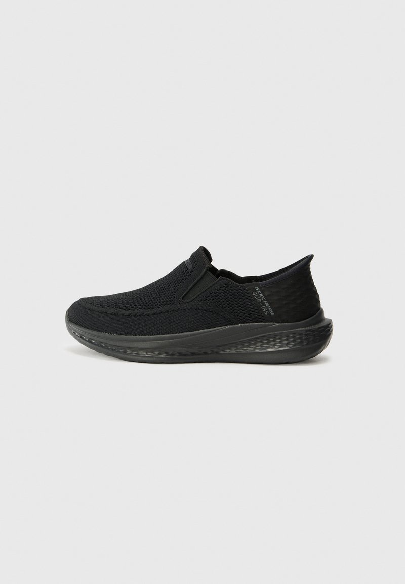 Black slip-on shoes made of breathable mesh with a textured heel and cushioned sole, featuring minimal stitching and a sleek design.