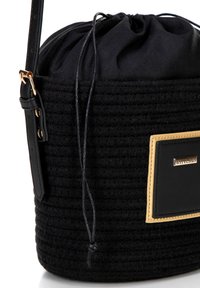 Borsa a secchiello nera intrecciata con chiusura a cordoncino, dettagli in pelle e placca logo dorata. Fodera in tessuto liscio e tracolla regolabile.