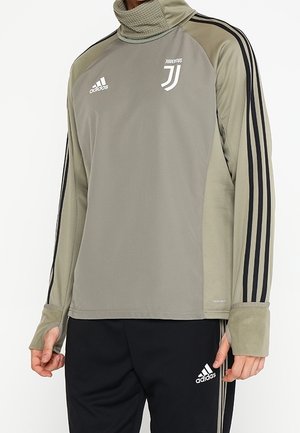 Maglia sportiva grigia a maniche lunghe Adidas Juventus con strisce nere e aperture per i pollici, abbinata a pantaloni neri Adidas.