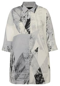 Vestito camicia a maniche lunghe di colore grigio chiaro con motivi astratti in bianco e nero, caratterizzato da un colletto e una chiusura con bottoni davanti.