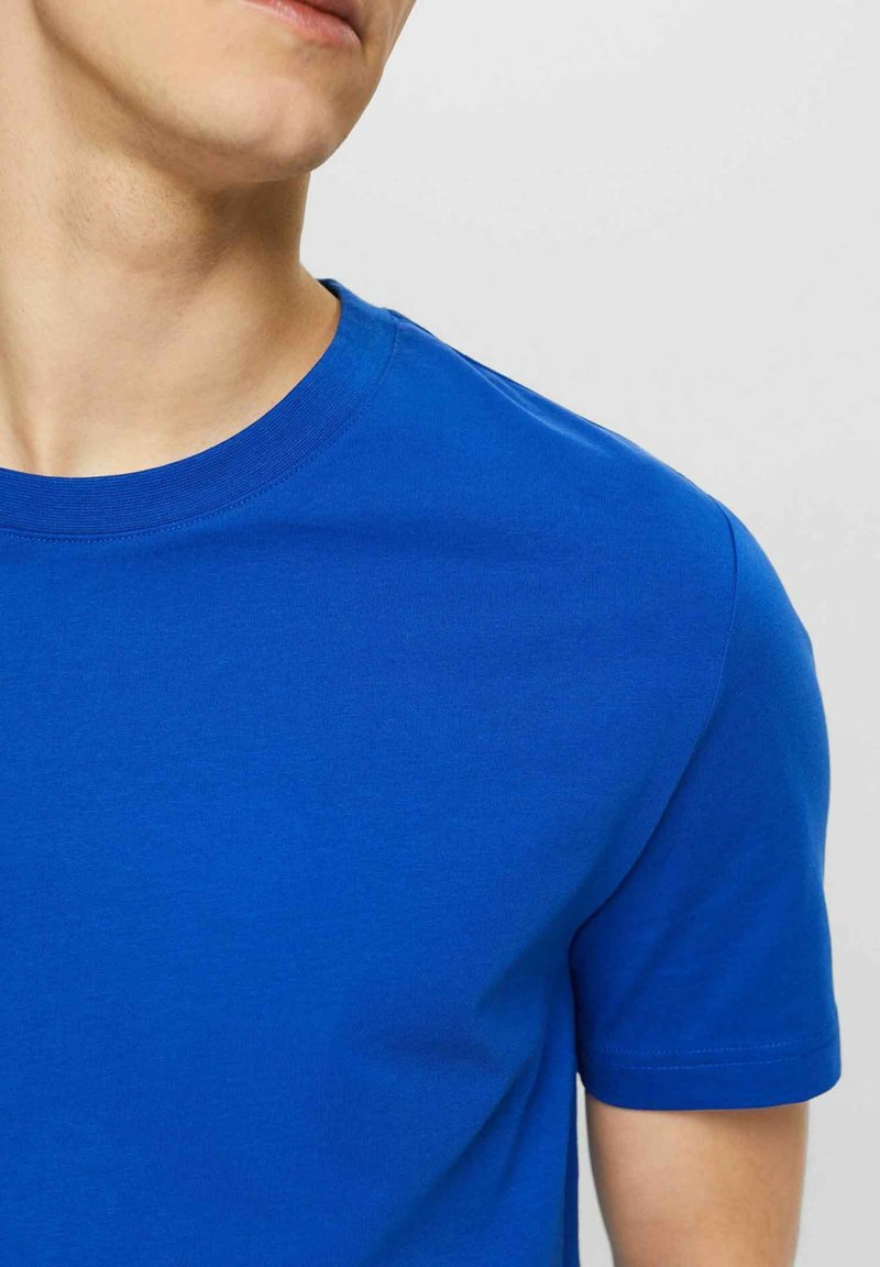 Blå bomulls t-shirt med rundad halsringning och korta ärmar, med en slät textur och klassisk passform. Inga synliga mönster eller detaljer.