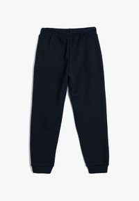 Navyblaue Jogginghose aus weichem Material, mit einem enganliegenden Bund und schmalen Bündchen an den Knöcheln.