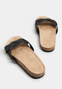 Sandali neri con cinturini, suola in sughero e soletta in suede color cammello. Presentano un design piatto e cinturini testurizzati per una vestibilità sicura.