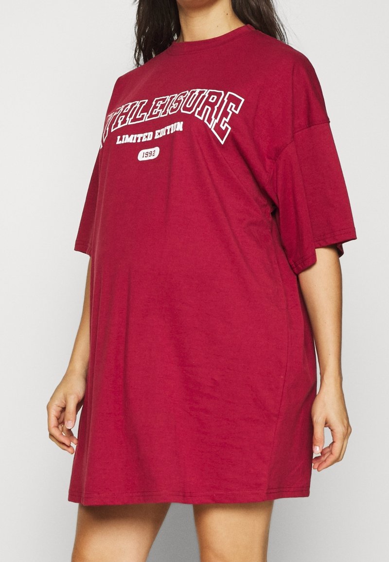 Oversized T-shirtjurk in bordeauxrood van zacht katoen. Voorzien van de tekst "Athleisure Limited Edition 1992" in wit over de borst. Korte mouwen.