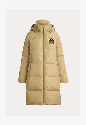 Pufferjas in licht beige met een ritssluiting aan de voorkant, een capuchon en zijzakken. Voorzien van horizontaal gestikt gedeelten en een badge op de borst.