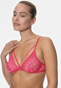 Rosa spets-bh med ett geometriskt mönster, underwire-stöd och justerbara axelband. Designen inkluderar genomskinlig mesh och vågiga kanter.