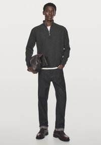 Gray zip-neck sweater, white shirt underneath, dark denim jeans, brown leather shoes, holding a dark leather jacket. Simple, modern design.