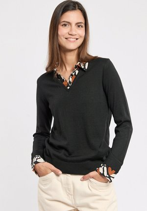 Pull noir en v à manches longues, avec un col et des poignets à motifs dans des tons naturels, texture douce, design ajusté.